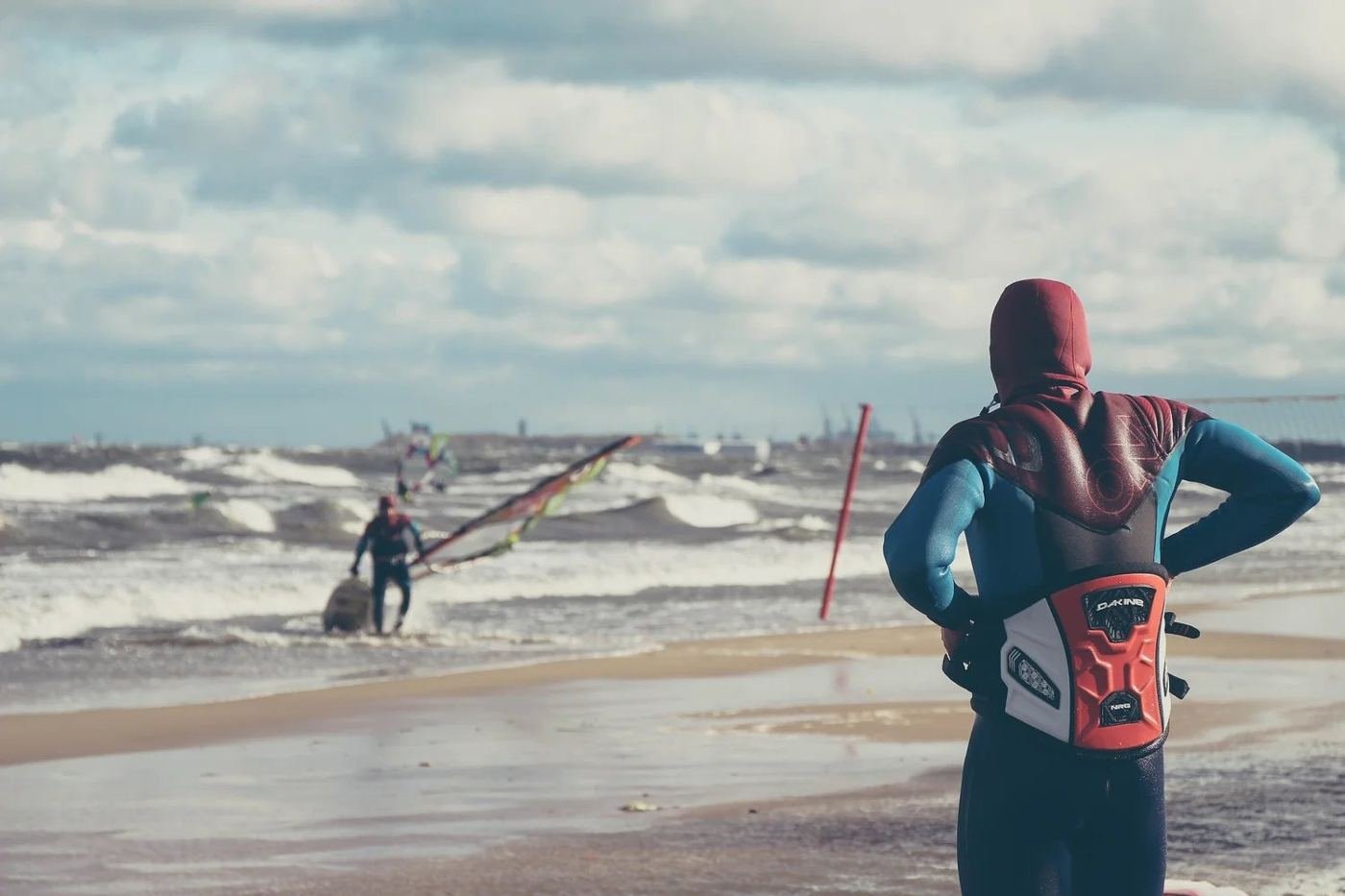 A young windsurfer watches the surf on a Tiree beach